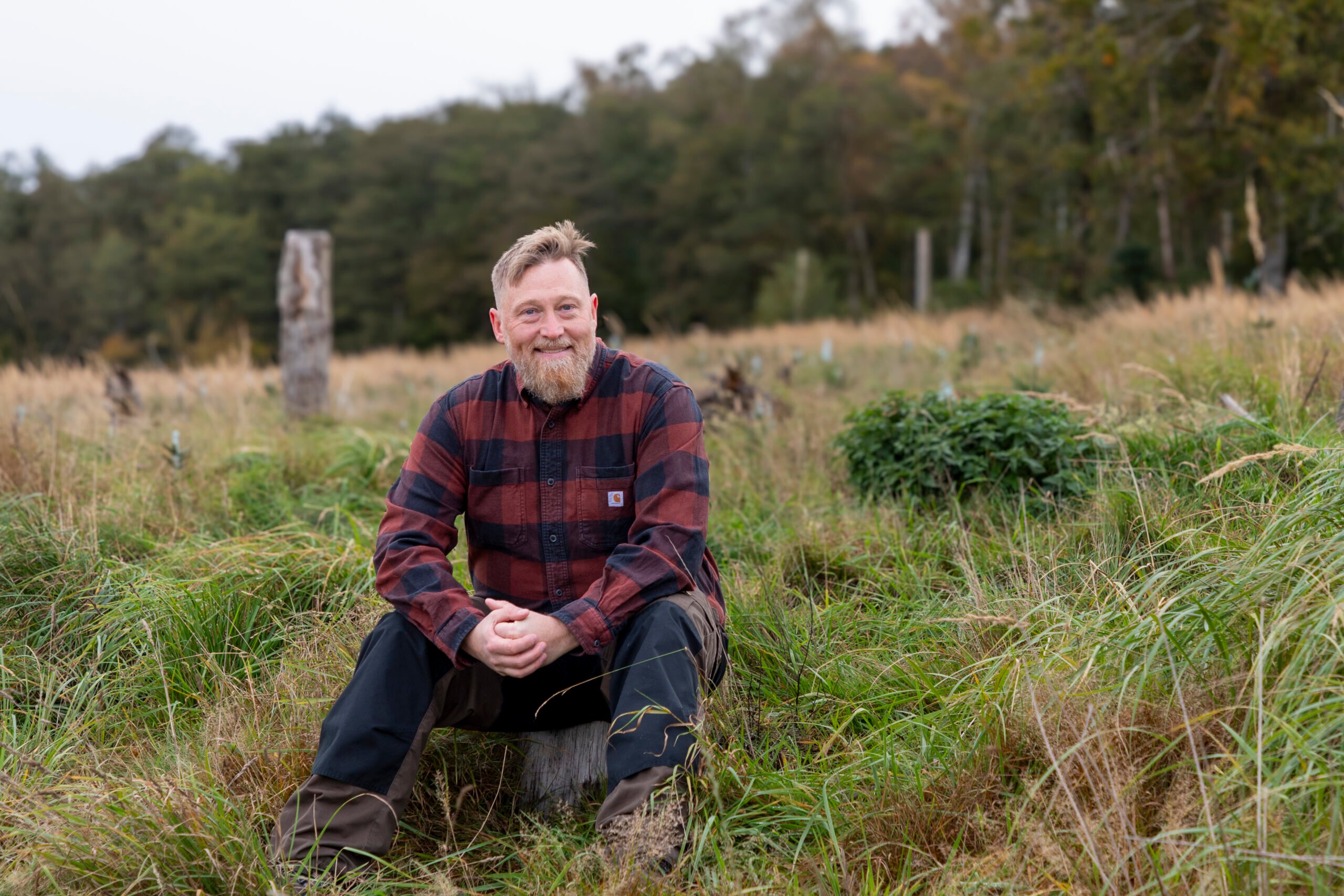 RobertWedmo sittande skog 3 Robert Wedmo från Ilmatar framför en skog.